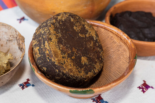 Piloncillo or sugar cane inside a clay bowl on a white tablecloth