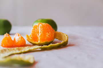Close-up ,The oranges  on the  table on white backdrop .The oranges have green peel ,peeling orange