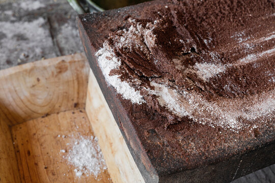 close up of ground white and black cacao on a stone metate 