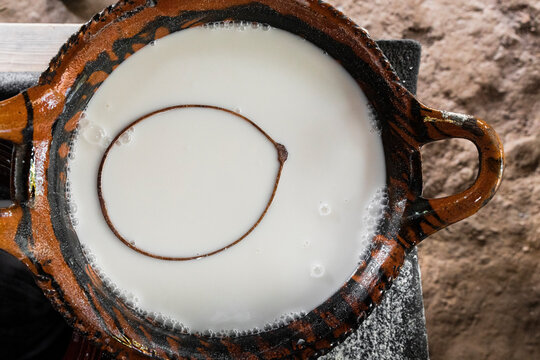 Closeup of white corn atole inside a clay pot