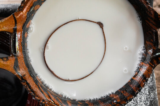 Top view of white corn atole inside a clay pot
