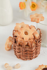 Basket with fresh shortbread cookies and glass of milk. Flower shaped cookies.