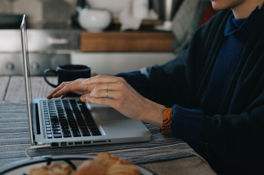 A woman working at kitchen with computer