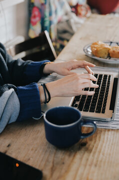 working at kitchen with a tea and a cake