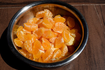 Slices of orange peeled completely and chopped and cut to make orange juice or orange fruit salad. Cut malta, mosambi, santra in container