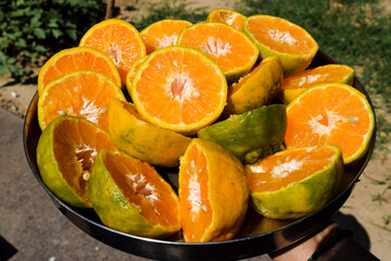 Female holding plate of half Cut Orange, Malta fruits sliced in to half to take out juice
