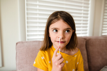 young girl gives herself a covid test