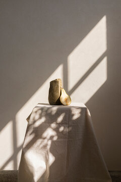 Minimalistic scene showing a pear and a lump of clay