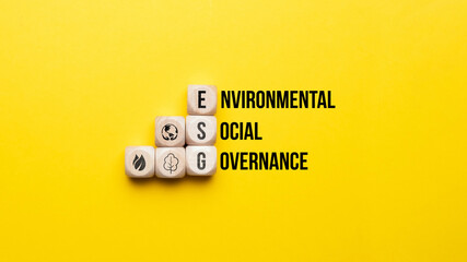 ESG or Environmental, Social, Governance. Text and icons on wooden cubes.
