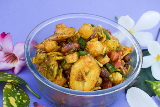 Farali bhelpuri made with faradi ingredients like banana chips, sago balls, mixture, tomato, capsicum on white background. Eaten during Fasting days like ekadashi, Mahashivratri . Blank space for text