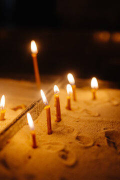 Lit candles flaming on candlestick in church 