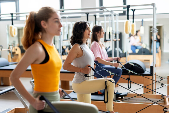 Women's team doing exercises on pilates machine