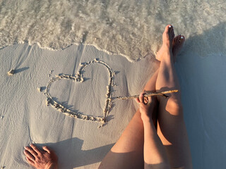 ugc beach travel, pov hand drawing heart on the sand