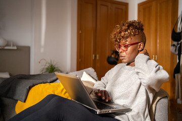 Black Woman With Neck Injury Using The Laptop At Home.