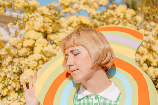 Woman looking away in front of yellow flowers