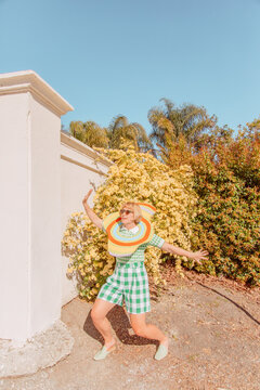 Woman strikes a pose in front of yellow flower bush