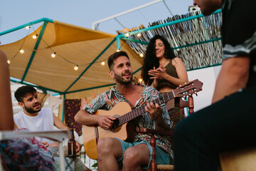 Group of friends playing live music in the evening