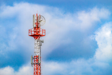 Radio mast (tower) with antennas for telecommunications and broadcasting and cloudy sky. Close-up