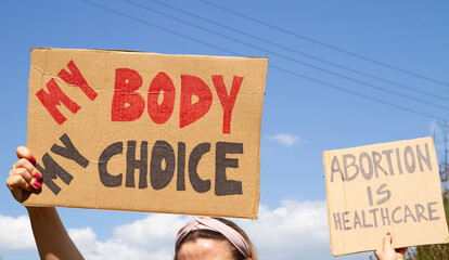 Protesters holding signs My Body My Choice and Abortion Is Healthcare. People with placards supporting abortion rights at protest rally demonstration.