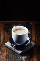 Cup of coffee on rustic wooden background.