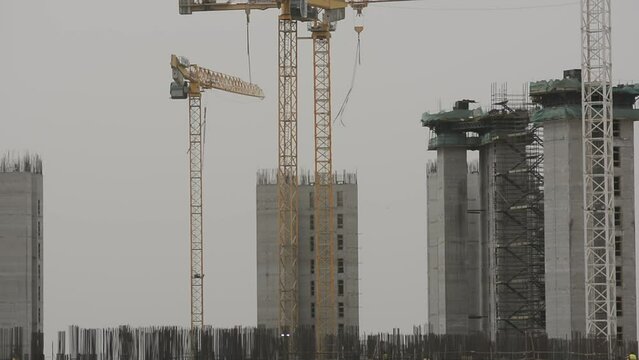 Construction site of new buildings in Egypt, acres of luxurious real estate residential buildings under construction with cranes, selective focus