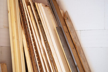 Boards for construction in the corner on background of a wall of foam concrete bricks