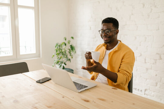 Afro-American Drinking Coffee At Home And Holding A Business Mee