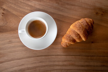 Croissant with espresso in white cup , directly above