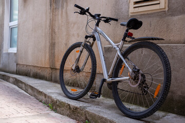 Naklejka na ściany i meble Sport city bike stands on the empty street near the wall
