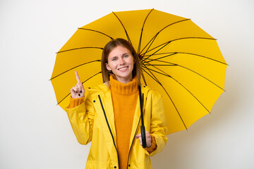 Young English woman with rainproof coat and umbrella isolated on white background showing and lifting a finger in sign of the best