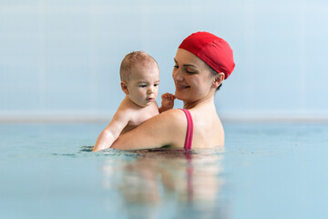 Mother teaching baby swimming pool