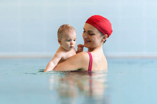 Mother teaching baby swimming pool