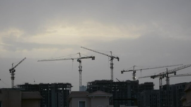 Construction site of new buildings in Egypt, acres of luxurious real estate residential buildings under construction with cranes, selective focus