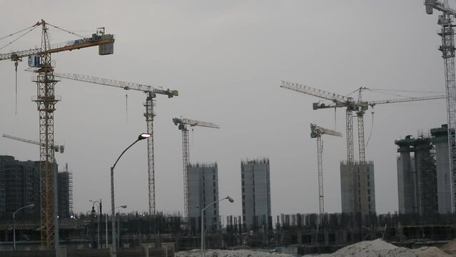 Construction site of new buildings in Egypt, acres of luxurious real estate residential buildings under construction with cranes, selective focus