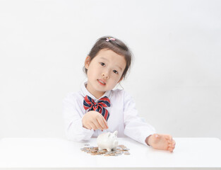 The lovely little girl has a piggy bank in her hand