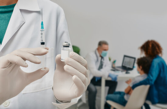 Routine vaccinations for a child. Doctor holding syringe with vaccine for seasonal or pandemic Influenza, but child needs to consult doctor before vaccination