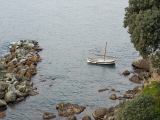Gozzo boat  anchored in a quiet bay of the Ligurian Riviera - 504579222