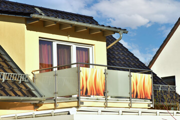 Balkon mit Metallgeländer als Sturzsicherung und Mattglas-Platten als Sichtschutz