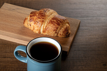 Croissant with a cup of full coffee, directly above