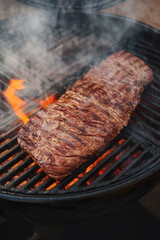 Traditional American barbecue bavette steak as close-up on a charcoal grill with fire