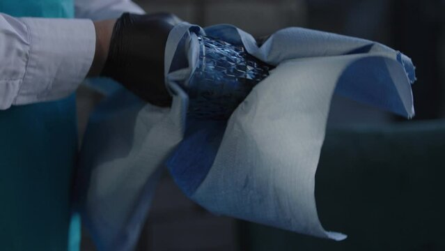 Restaurant staff wiping a glass mug wit a cloth before organizing.