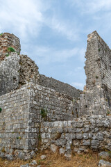 Ruins of ancient stone walls close-up, vertical. Remains of the ruined Rosafa Castle against the blue sky on a summer day