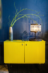 Yellow antique bedside table in a blue interior. High quality photo