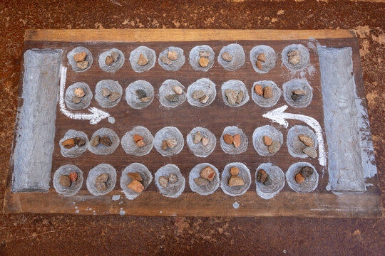 Traditonal african strategy game known as african chess also called Bao or kalah played using a hand made wooden board and stone pieces