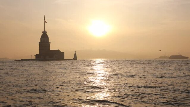 Maiden's Tower or Kiz Kulesi at foggy weather and sunset with cityscape of Istanbul and ferries. Travel to Istanbul background 4K video.