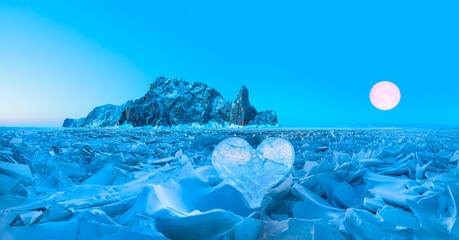Icy heart in a crack in the light of sunset full moon in the background -Lake Baikal, Siberia