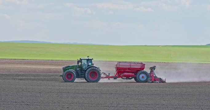 tractor cultivator or seeder plows the land, prepares for crops. dust on field