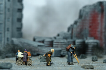 Miniature people toy figure photography. An elder couple with a grandchild refugee walking, moving...