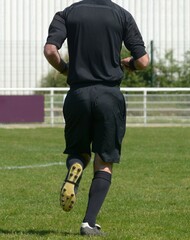 l'arbitre courant sur le terrain