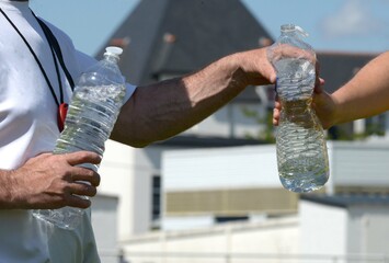 passage d'une bouteille d'eau au joueur de football	